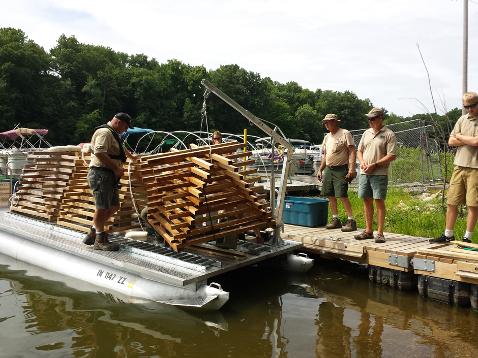 Pontoon boat carrying fish habitat structures on Monroe Lake
